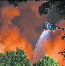  ?? Picture: Mhairi Edwards. ?? Firefighte­rs work to bring the blaze under control at its height as smoke fills the sky.