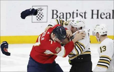  ?? RHONA WISE — THE ASSOCIATED PRESS ?? Boston Bruins center Charlie Coyle (13) watches teammate Brad Marchand and Florida Panthers defenseman Niko Mikkola fight during the second period. Boston rallied for a 4-3 win.