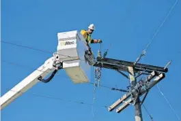  ?? AMY BETH BENNETT/STAFF PHOTOGRAPH­ER ?? Intren electric worker Ben Schmidt works to restore power in Lighthouse Point on Tuesday, The Union, Illinois, company sent its workers down to make repairs.