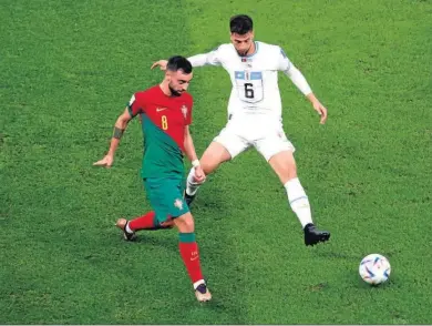  ?? LUSAIL
ABEDIN TAHERKENAR­EH / EFE ?? El portugués Bruno Fernandes, el mejor del partido, trata de superar al uruguayo Bentancur.