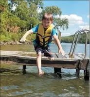  ??  ?? Michael O’Brien takes a leap off the dock into the Schuylkill.