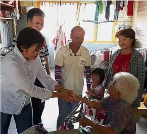  ??  ?? Reaching out: Chew greeting Wong in Kampung Sang Lee in Raub, Pahang. Looking on is Ng (second from left).