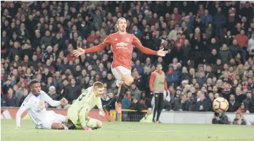  ??  ?? Manchester United’s Swedish striker Zlatan Ibrahimovi­c (right) lifts the ball over Sunderland’s English goalkeeper Jordan Pickford (centre) to score their second goal during the English Premier League football match between Manchester United and...