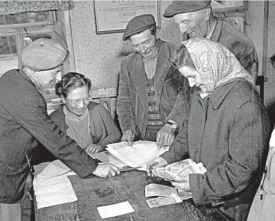  ?? FOTO ČTK ?? Transparen­tnost. Pokladní JZD Brniště v pohraniční­m okrese Česká Lípa vyplácí družstevní­kům doplatky v březnu 1960.