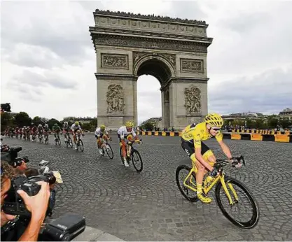  ??  ?? Auf diesen Moment haben die Fotografen gewartet: Chris Froome (rechts) fährt lächelnd über den Champ Elysees, seinem Tour-Sieg entgegen. Foto: David Stockman/dpa