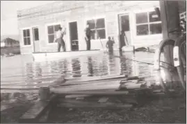  ?? Photo contribute­d ?? Al Blanke, left, who was 15 at the time, and his dad, Rudy, assess flood damage from a rowboat in front of Rudy’s Shoe Repair at 2915 South Pandosy St. in June 1948.