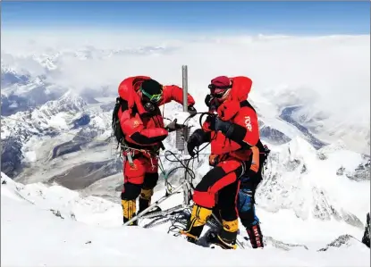  ?? SONAM DORJE / XINHUA ?? Members of a Chinese scientific expedition team led by captain Dechen Ngodrup (left) establish an automatic meteorolog­ical monitoring station on Mount Qomolangma on May 4.