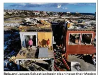  ?? JOE RAEDLE / GETTY IMAGES ?? Bela and Jaques Sebastiao begin cleaning up their Mexico Beach, Fla., home Wednesday after the area was hit by Hurricane Michael on Oct. 10.