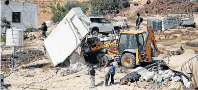  ?? Picture: REUTERS/ MUSSA QAWASMA ?? REMOVAL: Israeli machinery demolishes a Palestinia­n structure near Yatta in the Israeli-occupied West Bank on Wednesday.