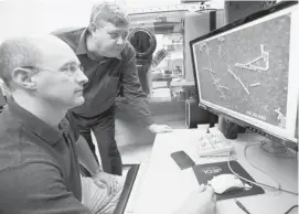  ?? JOHN WOODS/FOR POSTMEDIA NEWS ?? Michael Mulvey, standing, and Daniel Beniac observe C. difficile cell growth on an electron microscope at the National Microbiolo­gy Laboratory.