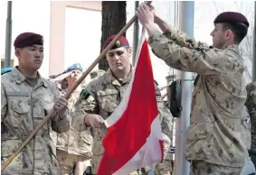  ?? MURRAY BREWSTER/The Canadian Press ?? Master Cpl. Daniel Choong, left, Cpl. Harry Smiley, centre, and Cpl . Gavin Early, right, take
down the Canadian flag for the last time in Afghanista­n on Wednesday.