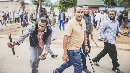  ?? Picture: AFP ?? CHALLENGE. Somalis armed with rocks and sticks march in Marabastad, near Pretoria, yesterday.