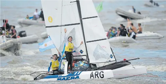  ?? GERMAN GARCIA ADRASTI ?? En el río. Dante Cittadini sostiene la Bandera argentina y Teresa Romairone, de pie a su lado, son la imagen de la felicidad.