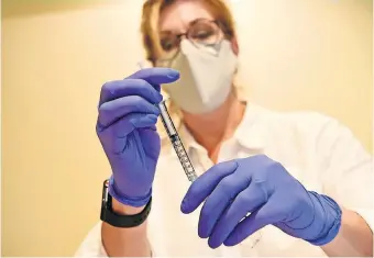  ?? [JOHNSON & JOHNSON VIA THE ASSOCIATED PRESS] ?? A pharmacist prepares to give an experiment­al COVID-19 vaccine.