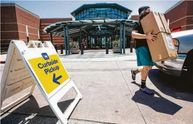  ?? Brett Coomer / Staff photograph­er ?? Brandon Becker brings packages from Zumiez at the Woodlands Mall to customers waiting to pick them up Friday.