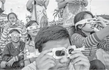  ?? Ulet Ifansasti / Getty Images ?? Solar eclipse experts say safety glasses, like the ones children in Indonesia used to watch a total solar eclipse in Palembang city on March 9, should be worn to protect the eyes of people watching the coming event.