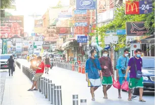  ?? PORNPROM SATRABHAYA ?? Locals walk on a near-empty Khao San Road. The Fiscal Policy Office initially forecasted economic growth at 1.3% this year.