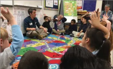  ?? RICHARD PAYERCHIN — THE MORNING JOURNAL ?? Teaching Artist Abraham Adams reads a book to first-grade students at Lorain City Schools’ Admiral King Elementary School. The program uses theater to help students understand their emotions.