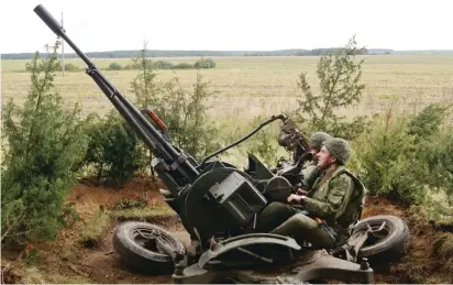  ??  ?? In this photo taken on Thursday, Belarusian soldiers aim their anti-aircraft gun at a training ground at an undisclose­d location in Belarus. Russia and Belarus began major war games, an operation involving thousands of troops, tanks and aircraft on...