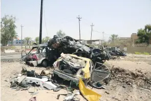  ?? (Reuters) ?? DESTROYED VEHICLES are seen at the site of a suicide car bomb in Khalis, north of Baghdad, Iraq, yesterday.