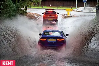  ?? ?? KENT
Dip your headlights: Motorists brave a flooded road in Wrotham Heath