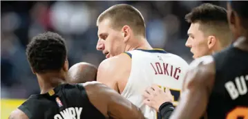  ?? DAVID ZALUBOWSKI AP ?? Nuggets center Nikola Jokic is restrained by Heat guards Kyle Lowry, left, and Tyler Herro after knocking over Heat forward Markieff Morris during a scrum in the second half of a game on Nov. 8 in Denver.