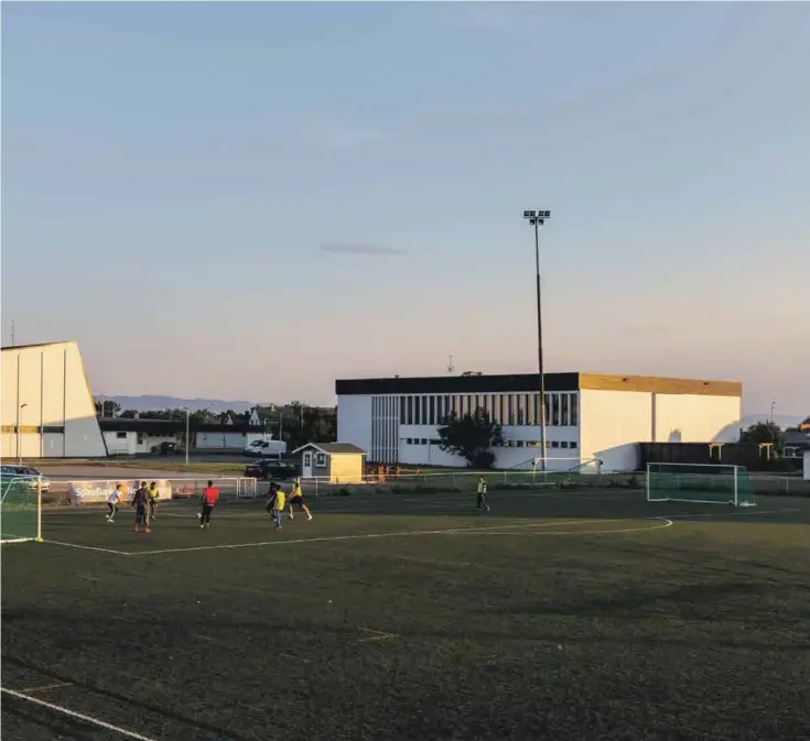 ??  ?? Ungdommer spiller fotball i kveldssole­n ved idrettshal­len i Vadsø. Det er blitt en måte å koble bort tankene og sorgen.