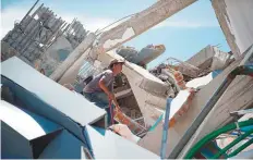  ?? AFP ?? A man searches for victims among the rubble of a ten-storey hotel after it collapsed following the quake in Sulawesi.