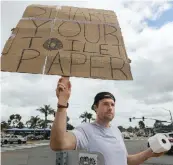  ??  ?? Jonny Blue, above, said his sign made drivers ask themselves why people were hoarding toilet paper.