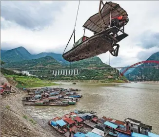  ?? ZHENG JIAYU / FOR CHINA DAILY ?? A fishing boat is hoisted ashore for dismantlin­g in Yichang’s Zigui county, Hubei province, on July 13 in preparatio­n for a 10-year fishing ban on the Yangtze River.