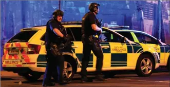  ?? The Associated Press ?? Armed police work at Manchester Arena after an explosion at the venue following an Ariana Grande gig killed at least 19 people and injured dozens more.