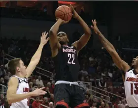  ??  ?? Nicholls State forward Brandon Moore Jr. (22) puts up a shot between the defense of Louisville guard Ryan McMahon (30), and forward V.J. King (13) during the first half of an NCAA college basketball game, in Louisville, Ky., on Thursday. AP PHOTO/ TIMOTHY D. EASLEY