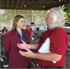  ??  ?? Rep. Elissa Slotkin, D-Mich., talks with a constituen­t after a veterans event on Friday at the Ingham County Fair in Mason, Mich. AP PHOTO/DAVID EGGERT