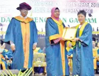  ??  ?? MASNIAH menyampaik­an sijil penghargaa­n kepada Kong Kah Yee Ellis.