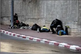  ?? AP/TSAFRIR ABAYOV ?? People take cover Tuesday after an air-raid warning siren sounds in Sderot, southern Israel.