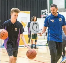  ?? Photo: Contribute­d ?? Brisbane Bullets guard Adam Gibson (rright) guides St Joseph's College student Jeremy Dagg through a dribbling skill.