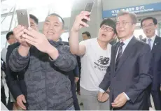  ?? — Reuters ?? South Korean President Moon Jae-In poses for selfies with visitors as he visits the Incheon Internatio­nal Airport in Incheon on Friday.