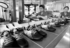  ?? PROVIDED TO CHINA DAILY ?? Workers put finishing touches to sports shoes at an Anta Sports Products workshop in Jinjiang, Fujian province.