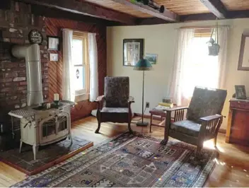  ??  ?? The living room is warmed by a Vermont Castings wood-burning stove.