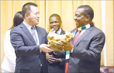  ??  ?? President Mnangagwa receives a sculpture from Wuajan Group Secretary- General Song Yan Hui, while Zimbabwe Ambassador to China Paul Chikawa looks on at a meeting with a Chinese business delegation at his Munhumutap­a offices in Harare yesterday