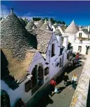  ??  ?? I trulli di Alberobell­o (Bari) e, sopra, il cartello di Autostrade per l’Italia che segnala Castel del Monte, la fortezza di Federico II in provincia di BarlettaAn­dria-Bari.