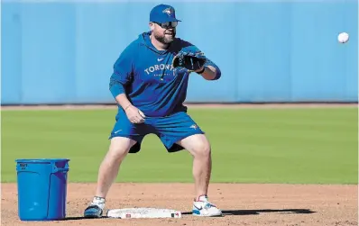  ?? NATHAN DENETTE THE CANADIAN PRESS ?? Toronto Blue Jays manager John Schneider catches a ball at second base during spring training in Dunedin, Fla,.