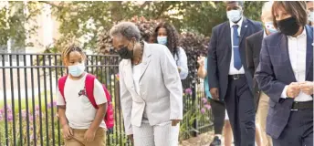  ??  ?? Mayor Lori Lightfoot walks with a student outside Courtenay Language Arts Elementary in Uptown on Monday.