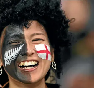  ?? GETTY IMAGES ?? A fan wears her divided loyalties on both cheeks last night – but most hardcore rugbyholic­s glued to the All Blacks-England semifinal were more one-eyed.