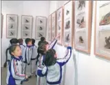  ?? LIU XIANGRUI / CHINA DAILY ?? Youngsters visit the bird illustrati­ons show in Beijing.