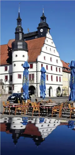  ?? FOTO: MARTIN SCHUTT / DPA ?? Abgesperrt sind Tische und Stühle eines Eiscafés auf dem Markt vor dem historisch­en Rathaus in Hildburgha­usen. In Thüringen werden die ersten Anti-Corona-Maßnahmen gelockert.