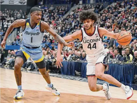  ?? Jessica Hill/Associated Press ?? UConn’s Andre Jackson Jr. (44) dribbles while defended by Marquette’s Kam Jones (1) on Tuesday night.