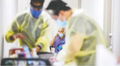  ?? CARLOS OSORIO / REUTERS FILES ?? A senior waits her turn as nurses in Toronto administer the Moderna vaccine on March 25. Studies show that the
elderly and infirm don't get the full benefits of the second dose if it is delayed, Diane Francis writes.