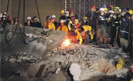  ?? Photograph­s by Gary Coronado Los Angeles Times ?? RESCUERS work to free a slab of concrete for removal by crane as search efforts continued at a residentia­l building that collapsed in Mexico City’s Condesa area.