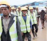  ?? — Reuters ?? Rohingya refugees who work as road constructi­on workers at the Kutupalong refugee camp walk towards their spot in Cox’s Bazar.